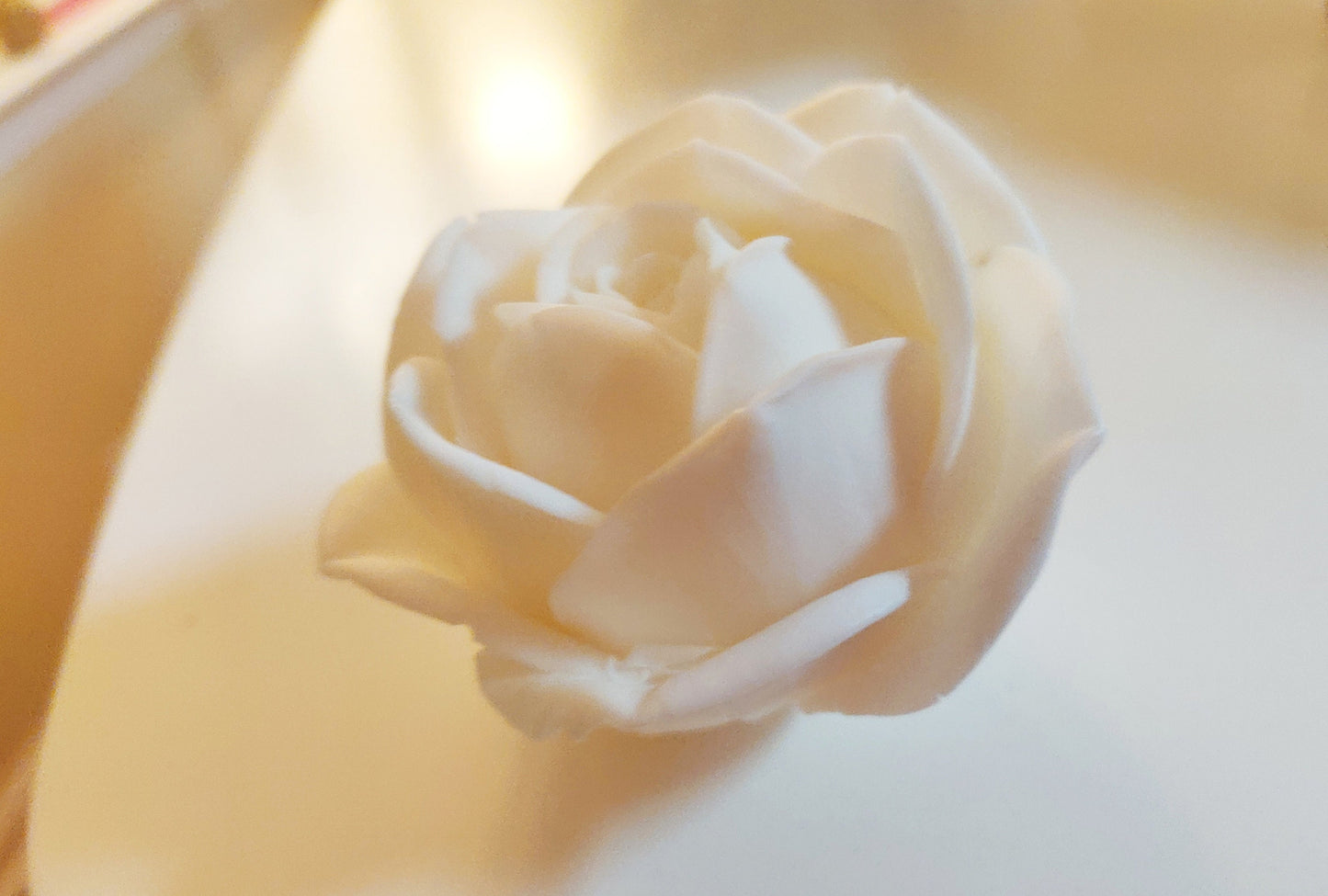 Another close-up of a hand-poured white rose soap showing intricate petal details.