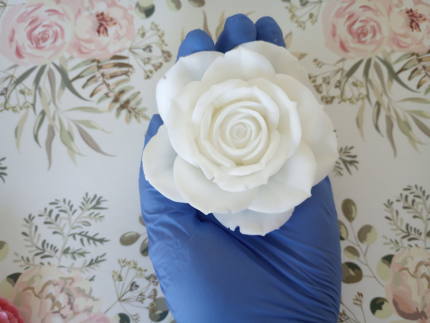 Top-down view of a 3.5-inch wide blooming rose soap bar, white rose soap flower showing 2 inch height, perfect as a luxury guest soap or floral bath decor.  Rose held in gloved hand.  
