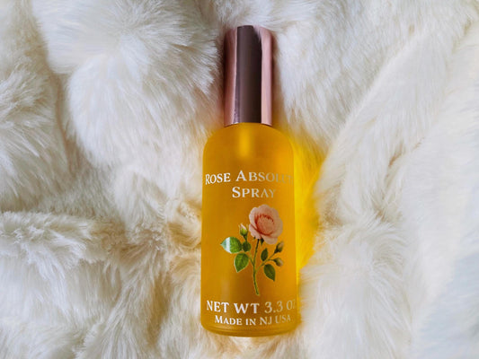 Rose Absolute oil spray with real high quality rose absolute in a frosted glass bottle on a white background with an ornate rose label.