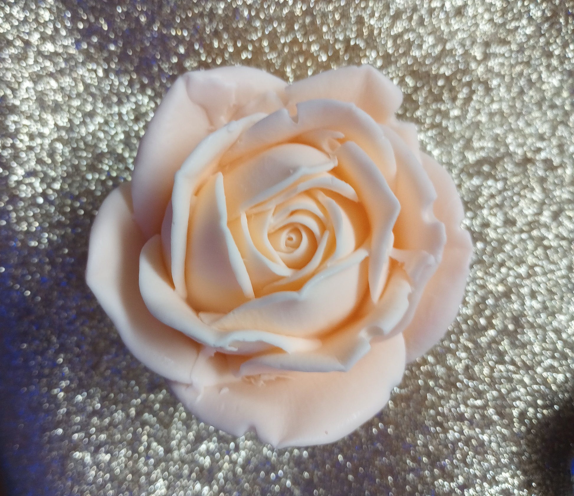 Close-up of the lifelike petals of a peach rose soap featuring a shea butter base.